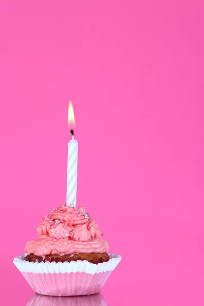 Belo cupcake com vela no fundo rosa — Fotografia de Stock