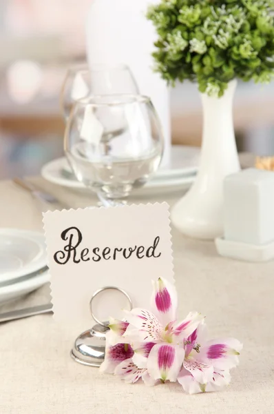 Cartello riservato sul tavolo del ristorante con piatti e bicchieri vuoti — Foto Stock