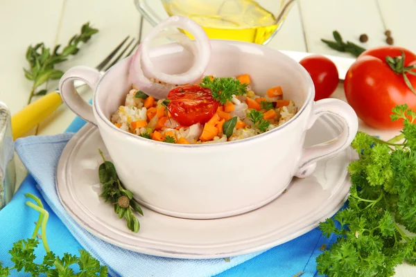 Delicious rice with vegetables and herbs in pot on wooden table close-up — Stock Photo, Image