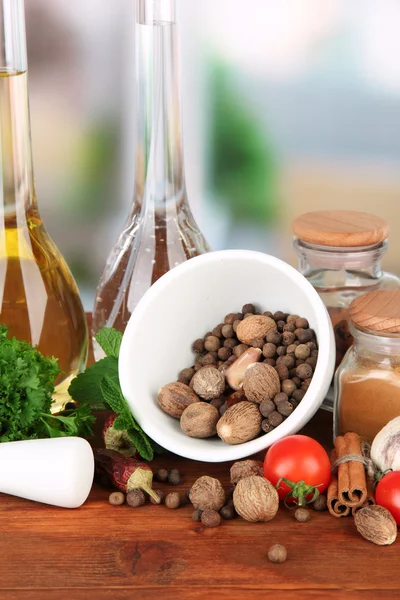 Composition of mortar, bottles with olive oil and vinegar, and green herbals, on bright background — Stock Photo, Image