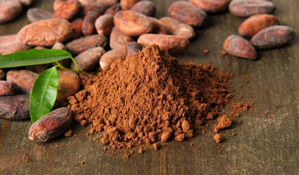 Kakao çekirdekleri ve ahşap zemin üzerine kakao tozu — Stok fotoğraf