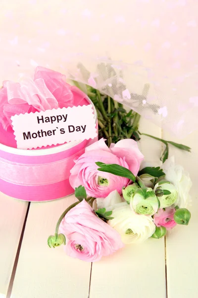 Ranunculus (buñuelos persas) y regalo para el día de las madres, sobre fondo de madera blanca —  Fotos de Stock