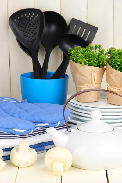 Configurações da cozinha: utensílio, pegadores de panela, toalhas e muito mais na mesa de madeira — Fotografia de Stock