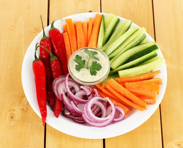 Bâtonnets de légumes crus assortis dans une assiette sur une table en bois fermer — Photo