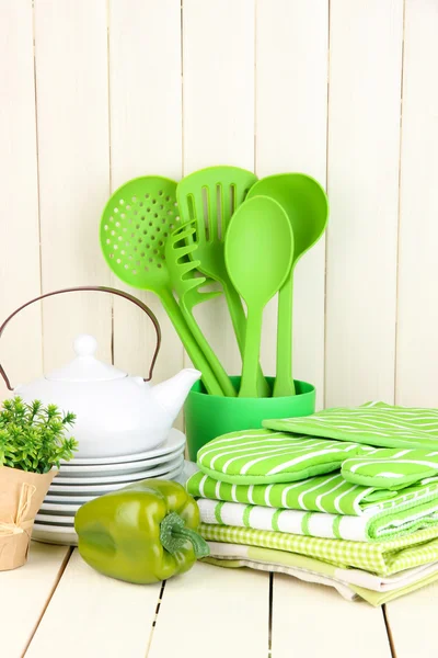 Ajustes de cocina: utensilios, agarraderas, toallas y más en la mesa de madera — Foto de Stock