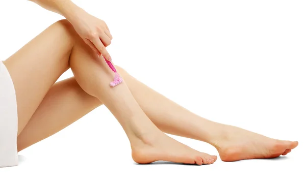 Hermosa mujer se afeita la pierna, aislada en blanco — Foto de Stock