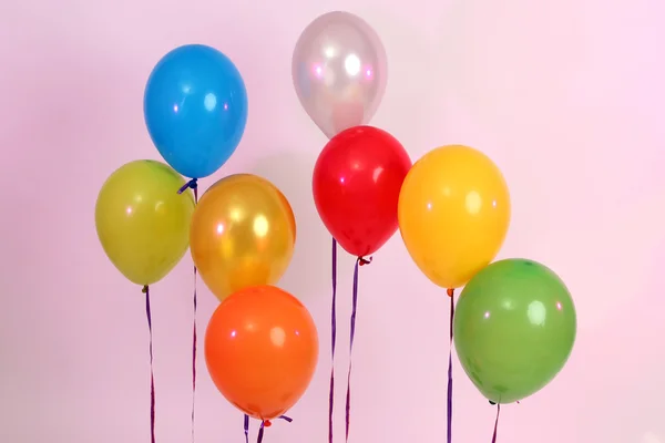 Viele helle Luftballons auf rosa Hintergrund — Stockfoto