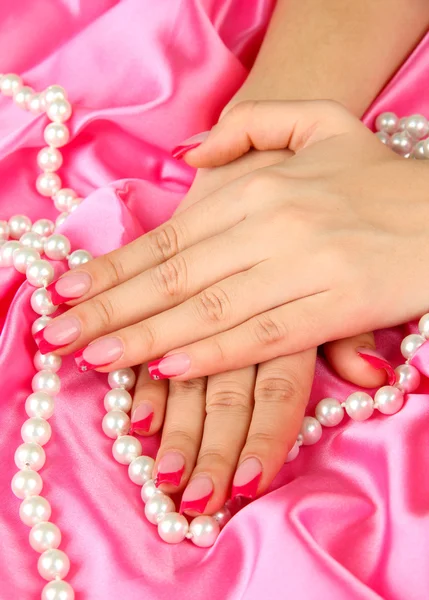 Weibliche Hände auf farbigem Stoff Hintergrund — Stockfoto