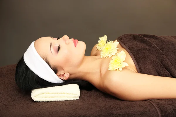 Hermosa joven en el salón de spa, sobre fondo oscuro — Foto de Stock