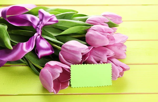 Krásnou kytici fialové tulipány na zelené dřevěné pozadí — Stock fotografie