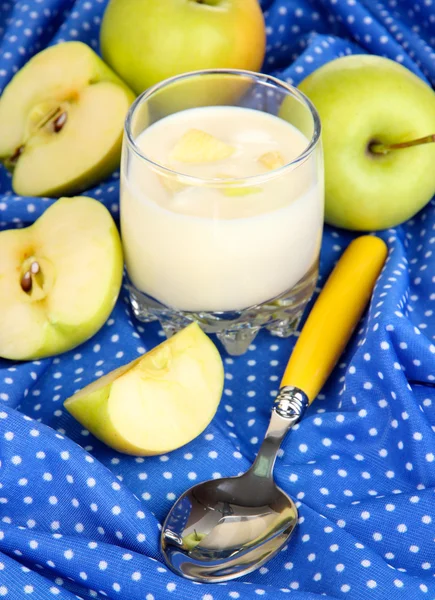 Delizioso yogurt in vetro con mela sulla tovaglia blu — Foto Stock