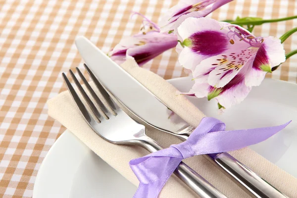 Cenário festivo mesa de jantar com flores no fundo quadriculado — Fotografia de Stock