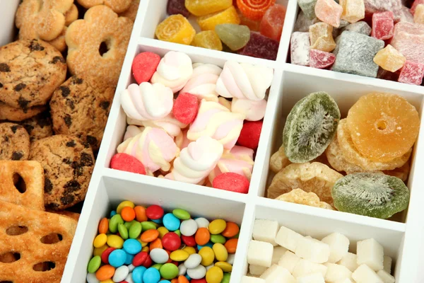 Multicolor godis och kakor i vit trä låda på nära håll — Stockfoto