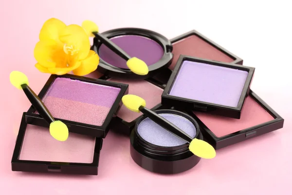 Brillantes sombras de ojos y cepillos de esponja para cimentar sobre fondo rosa —  Fotos de Stock