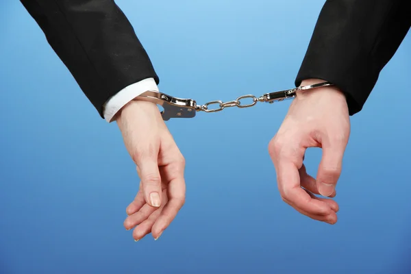 Man and woman hands and breaking handcuffs on color background — Stock Photo, Image