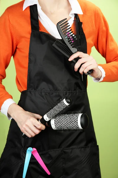 Hairdresser in uniform with working tools, on color background — Stock Photo, Image