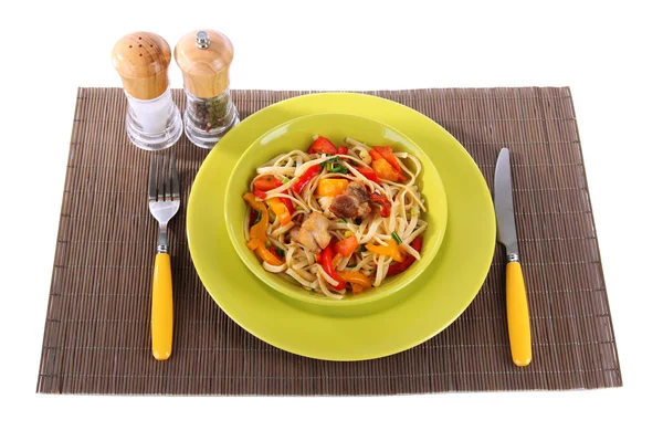 Nudeln mit Gemüse auf Teller auf Holzmatte isoliert auf weiß — Stockfoto