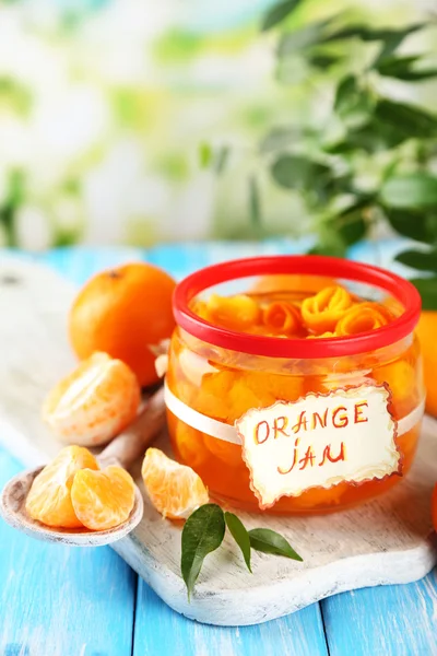Orangenmarmelade mit Schale und Mandarinen, auf blauem Holztisch — Stockfoto