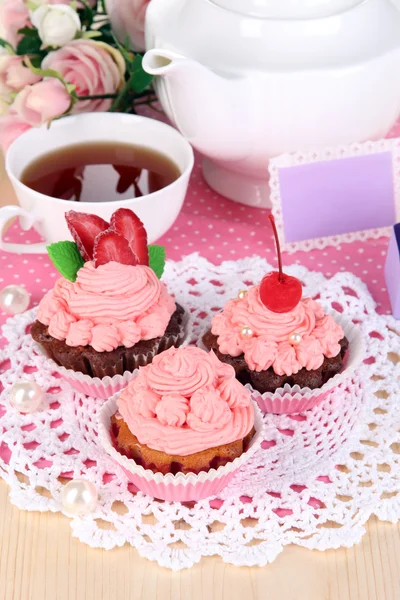 Beautiful strawberry cupcakes and flavored tea on dining table close-up — Stock Photo, Image