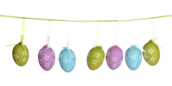 Coloridos huevos de Pascua colgados en cintas aisladas en blanco — Foto de Stock