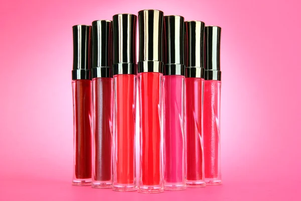Beautiful lip glosses, on pink background — Stock Photo, Image