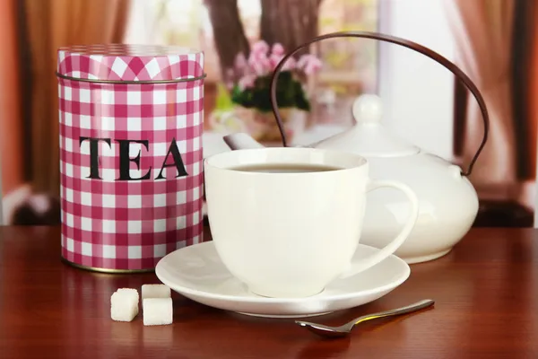 Jar and cup of tea on table in room — Stock Photo, Image