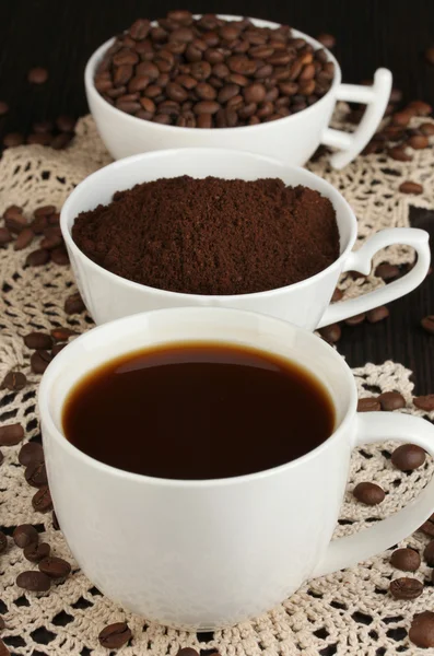 Diferentes tipos de café em três xícaras em mesa de madeira — Fotografia de Stock