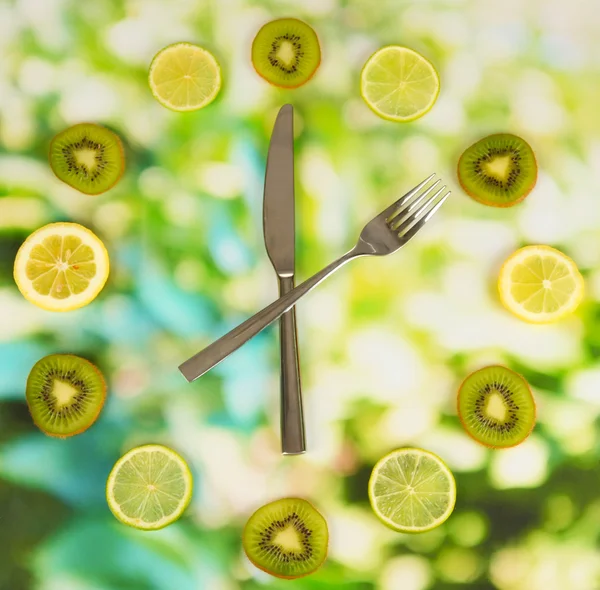 Часы из киви, лайма и лимона, на ярком фоне — стоковое фото