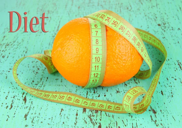 Orange with measuring tape, on color wooden background — Stock Photo, Image