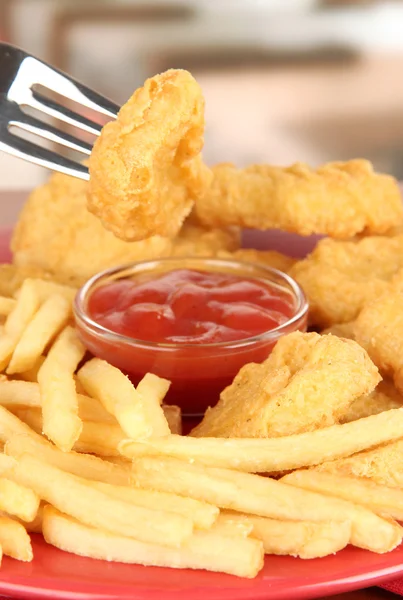 Gebakken kipnuggets met patat en saus op tafel in café — Stockfoto