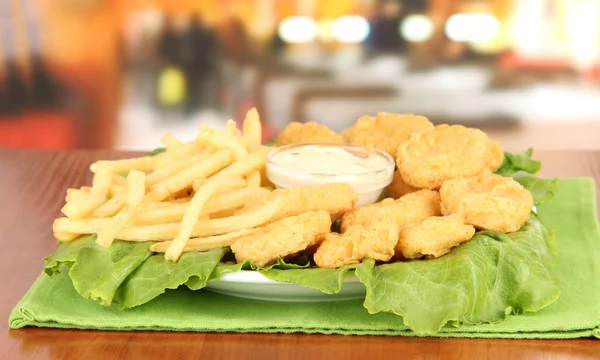 Smażone nuggets z kurczaka z frytkami i sosem na stole w kawiarni — Zdjęcie stockowe