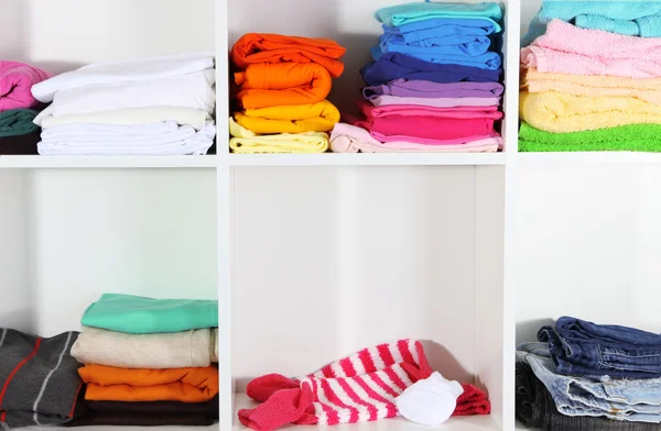 Clothes neatly folded on shelves — Stok fotoğraf