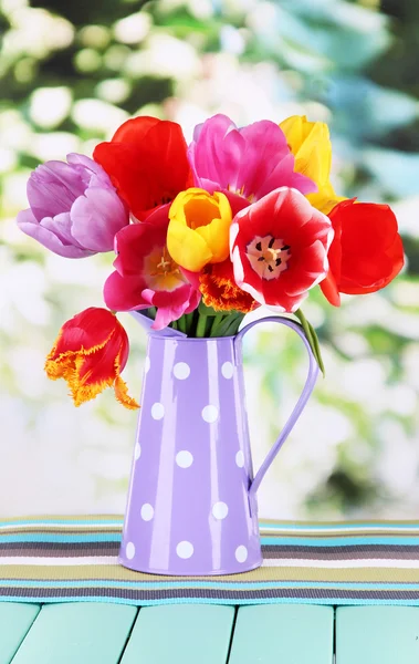 Красиві тюльпани в букеті на столі на яскравому фоні — стокове фото
