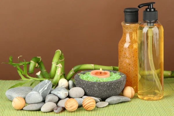 Bodegón con planta de bambú verde y piedras, sobre estera de bambú sobre fondo de color —  Fotos de Stock