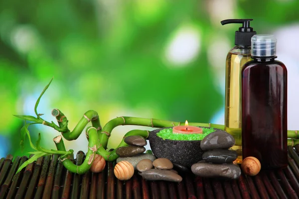 Bodegón con planta de bambú verde y piedras, sobre estera de bambú, sobre fondo brillante — Foto de Stock