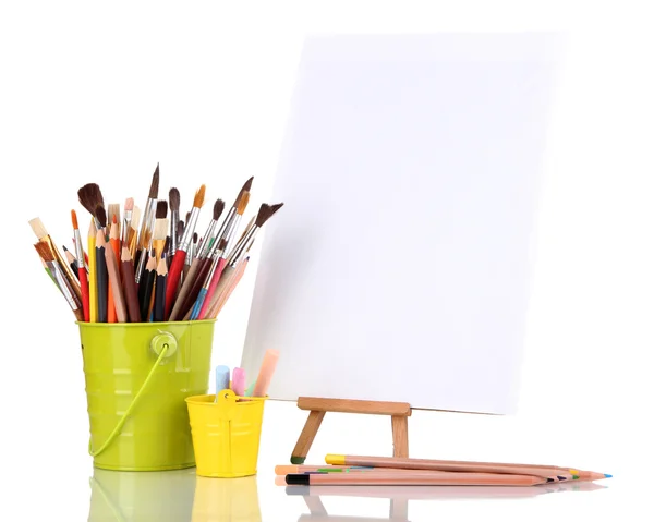 Small easel with sheet of paper with art supplies isolated on white — Zdjęcie stockowe