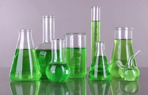 Test-tubes with green liquid on gray background — Stock Photo, Image