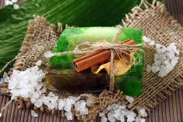 Hand-made soap, sea salt and leaf on grey bamboo mat — Stock Photo, Image