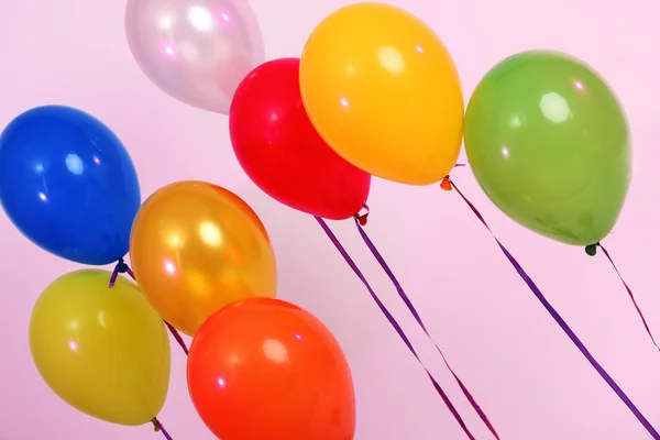 Veel heldere ballonnen op roze achtergrond — Stockfoto