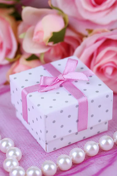 Роза и подарочная коробка на розовой ткани — стоковое фото