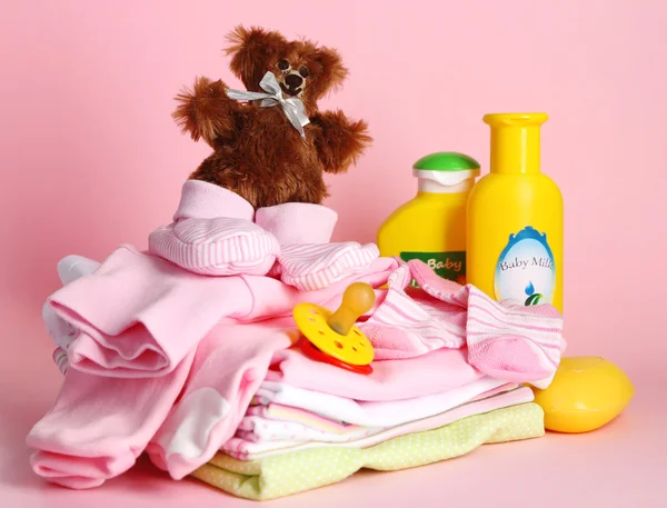 Куча детской одежды на розовом фоне — стоковое фото