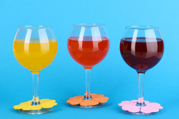 Cocktails colorés avec décor lumineux pour verres sur fond bleu — Photo