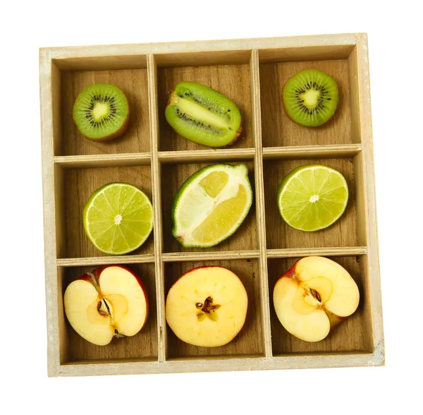 Fruta en rodajas en caja de madera aislada en blanco —  Fotos de Stock