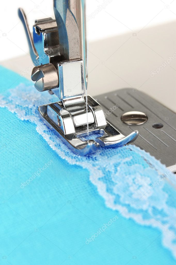Closeup of sewing machine working part with blue cloth