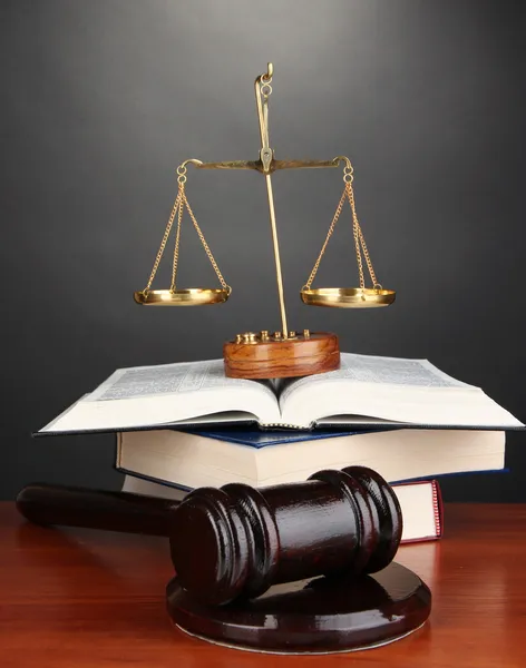 Holzgabel, goldene Maßstäbe der Gerechtigkeit und Bücher auf grauem Hintergrund — Stockfoto