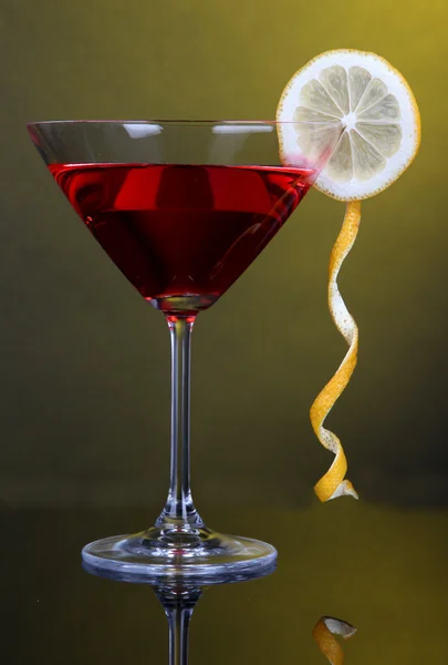 Red cocktail in martini glass on dark yellow background — Stock Photo, Image