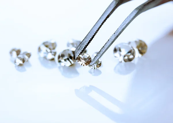Bellissimo cristallo lucente (diamante) nelle pinzette, isolato su bianco — Foto Stock