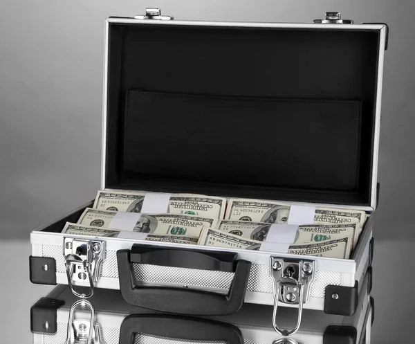 Suitcase with 100 dollar bills on grey background — Stock Photo, Image