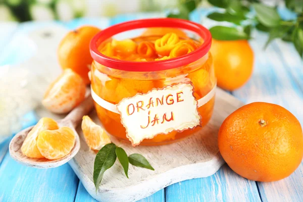 Engarrafamento de laranja com raspas e tangerinas, sobre mesa de madeira azul — Fotografia de Stock