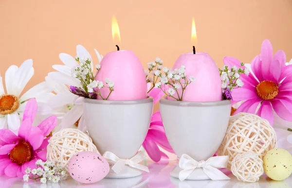 Candele pasquali con fiori su sfondo beige — Foto Stock